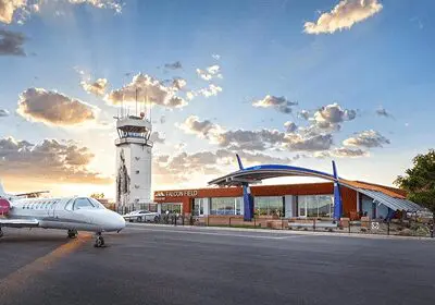 Small airport terminal with control tower at sunset.
