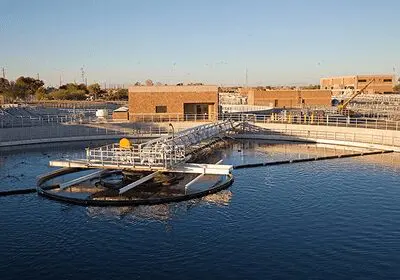 A modern water treatment facility with clear blue water under a blue sky.