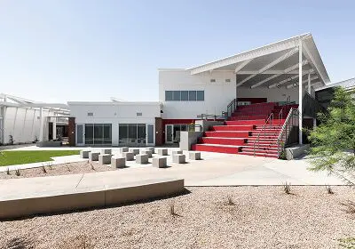 Outdoor amphitheater with red seating and modern architecture under clear sky.