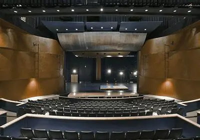Empty modern theater auditorium with stage and seats.