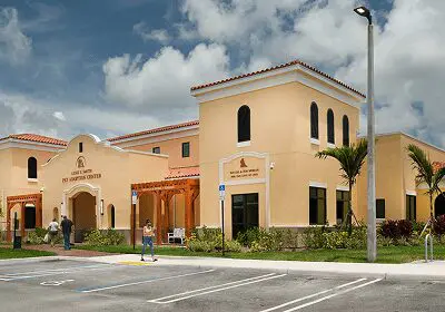 A modern building with a beige facade and clear blue sky.