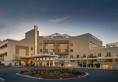 A modern hotel building during sunset with a roundabout in front.