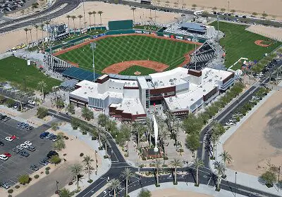 Aerial view of a modern baseball stadium with surrounding parking and desert landscape.