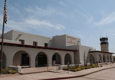 Building with arched windows and an outdoor patio under a partly cloudy sky.