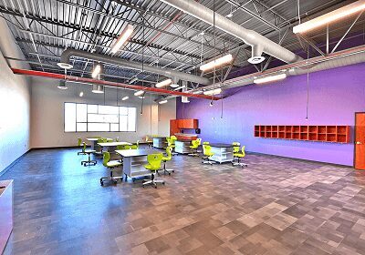 Modern classroom with colorful chairs and purple walls.