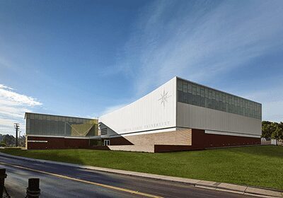 Modern building with angular white facade under a clear blue sky.