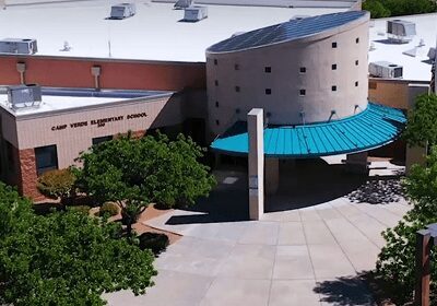 Modern building with curved architecture and surrounding trees.