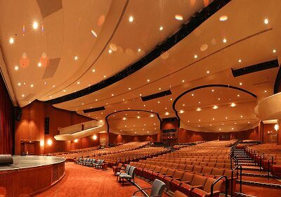 Empty auditorium with warm lighting and curved ceiling design.