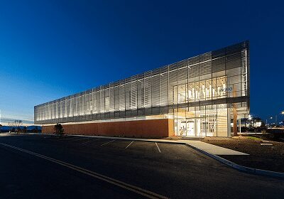 Modern building with illuminated glass facade at dusk.