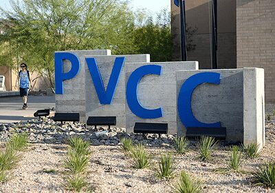 Concrete blocks with blue letters spelling 'PVCC' outdoors.