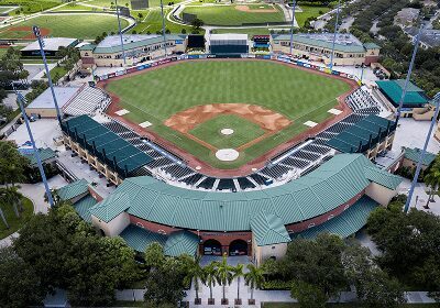 Aerial view of a baseball stadium with empty seats and green field.