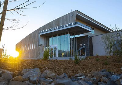 Modern building with glass entrance illuminated by sunset light.