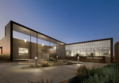 Modern building with large glass windows at dusk.