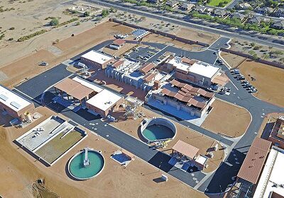 Aerial view of a large industrial or treatment facility with circular tanks and multiple buildings.
