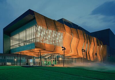 Modern building with a striking orange facade at dusk.