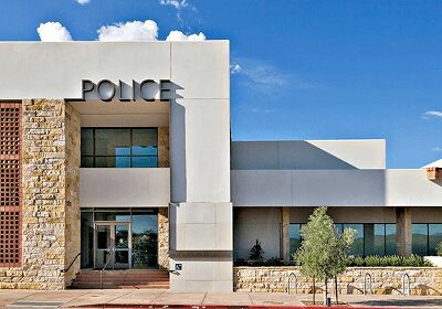 Exterior view of a modern police station building under a partly cloudy sky.