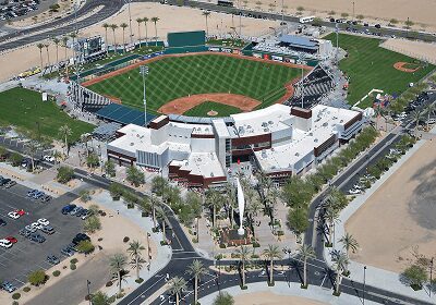 Aerial view of a modern baseball stadium with surrounding parking and desert landscape.